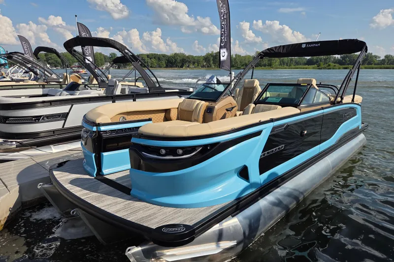 Slide: The Image of 2026 Godfrey SA pontoon boat in blue, docked on a sunny day. - 10