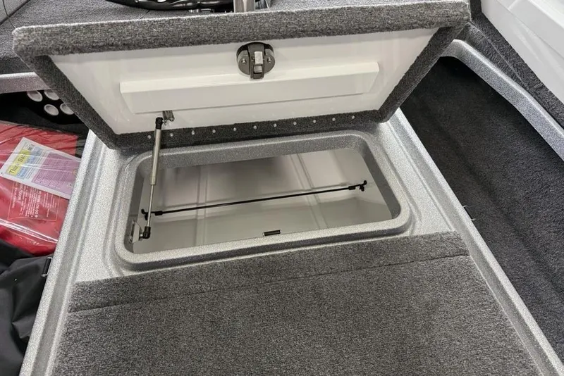 Slide: The Image of Open storage compartment in 2025 Phoenix 920 Elite II boat, featuring carpeted interior. - 13