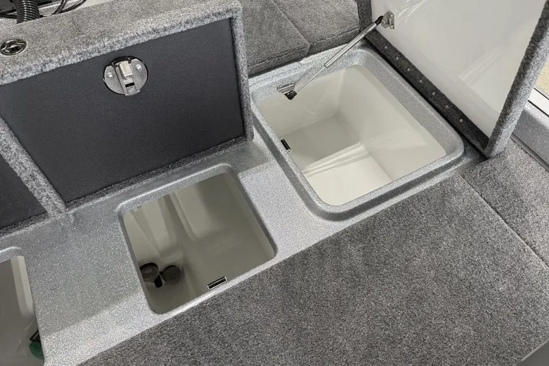 Slide: The Image of 2025 Phoenix 920 Elite II boat storage compartments with open lids, showcasing interior space. - 17