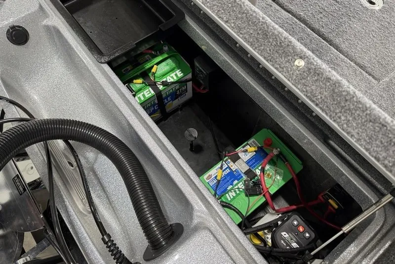 Slide: The Image of Open battery compartment of 2025 Phoenix 920 Elite II boat, showing Interstate batteries and wiring. - 21