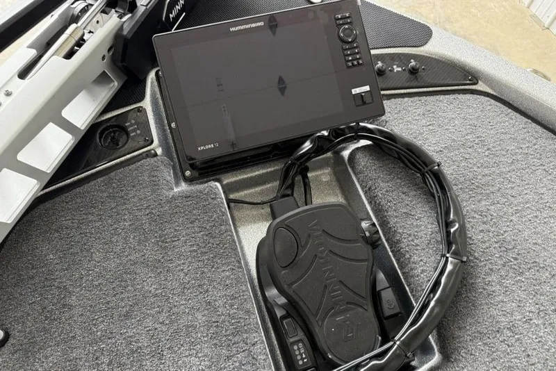 Slide: The Image of 2025 Phoenix 920 Elite II boat dashboard with Humminbird Xplore 12 display and Minn Kota foot pedal. - 7