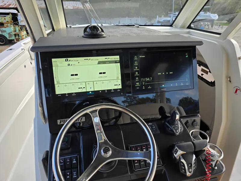 Slide: The Image of 2025 Pursuit S 328 boat dashboard with modern controls and dual display screens. - 15