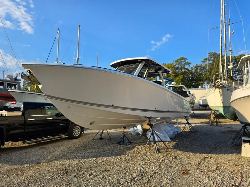 Slide: The Image of 2025 Pursuit S 328 boat on display in a marina, clear blue sky background. - 3