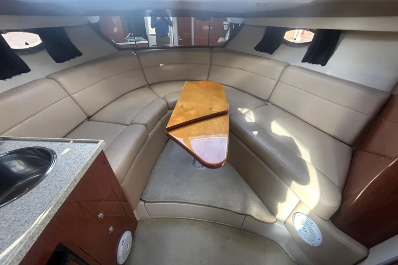 Slide: The Image of 2007 Regal 3060 Express Cruiser interior with beige seating and wooden table. - 11