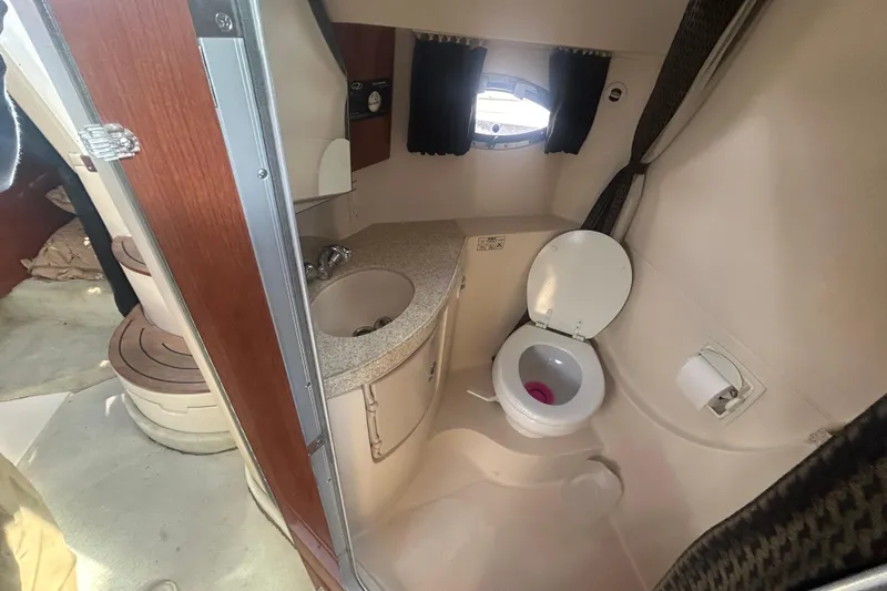 Slide: The Image of 2007 Regal 3060 Express Cruiser bathroom with sink, toilet, and porthole window. - 9