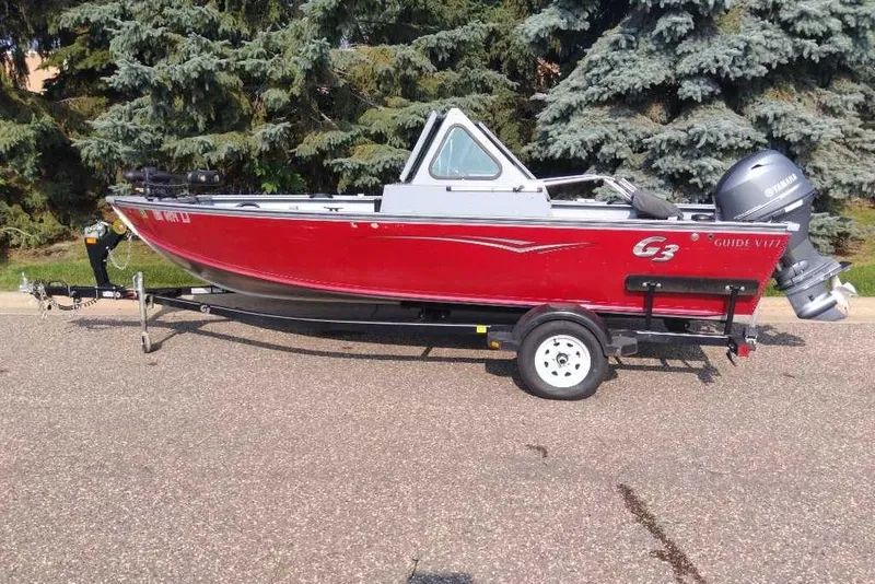 The Image of 2015 G3 Guide V177 WT boat on trailer, red exterior, parked outdoors. - 1