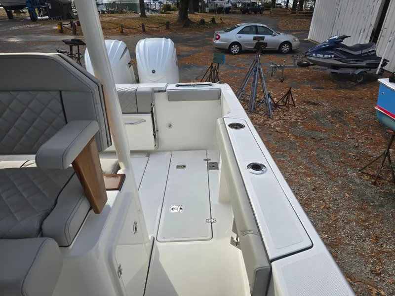 Slide: The Image of 2025 Pursuit S 288 boat interior with seating and storage, parked outdoors. - 21