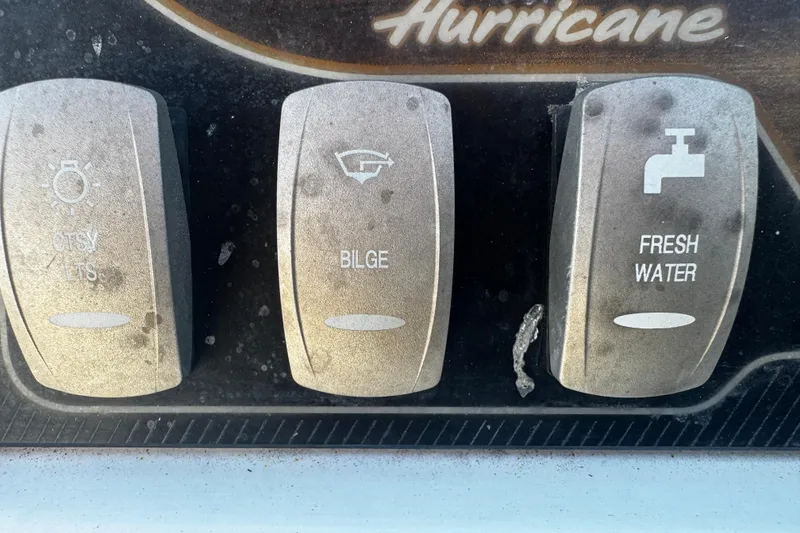 Slide: The Image of Control panel of a 2019 Hurricane SunDeck 2690 OB boat with switches for lights, bilge, and fresh water. - 11
