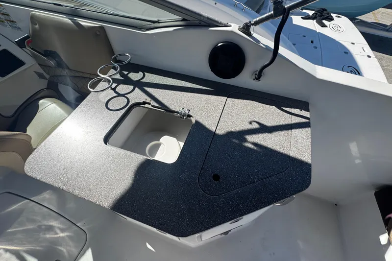 Slide: The Image of 2019 Hurricane SunDeck 2690 OB boat interior with sink and cup holders. - 2