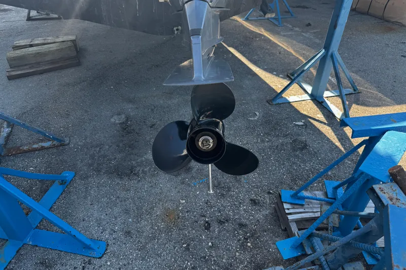 Slide: The Image of 2019 Hurricane SunDeck 2690 OB boat propeller on dry dock with blue stands. - 23