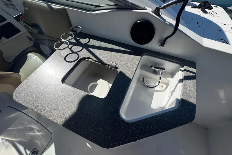 Slide: The Image of 2019 Hurricane SunDeck 2690 OB boat interior with sink and cup holders. - 3