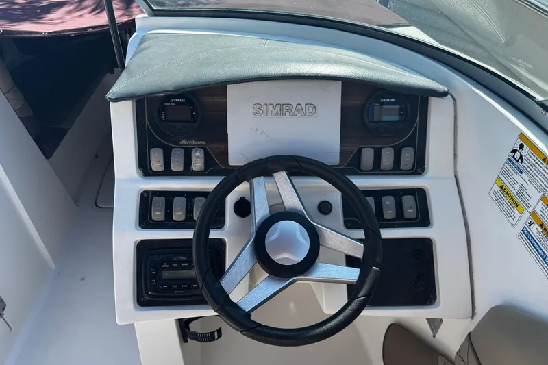 Slide: The Image of 2019 Hurricane SunDeck 2690 OB boat dashboard with steering wheel and control panel. - 4