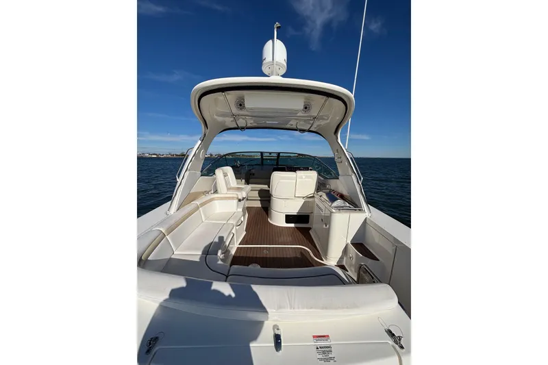 Slide: The Image of 2010 Sea Ray 370 Sundancer boat interior with seating, on open water under clear blue sky. - 16