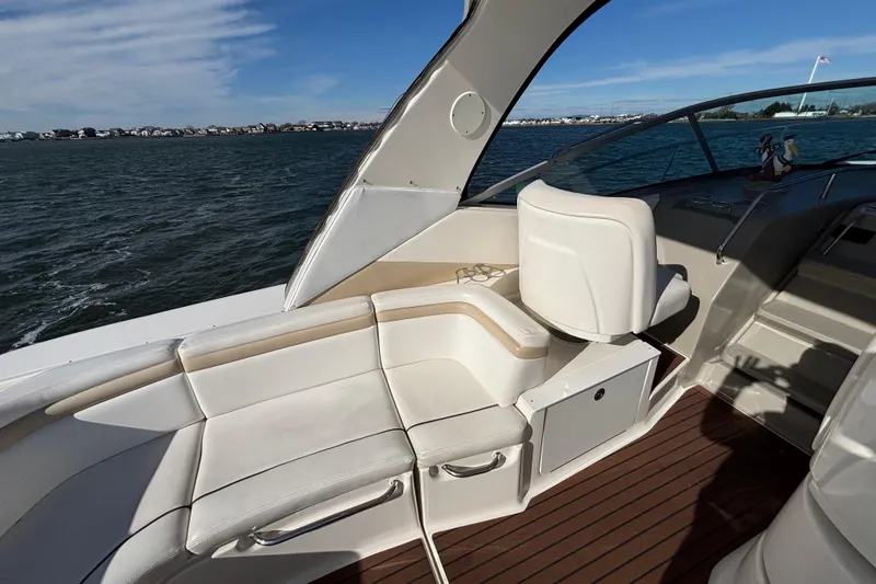 Slide: The Image of 2010 Sea Ray 370 Sundancer boat interior with white seating and ocean view. - 20