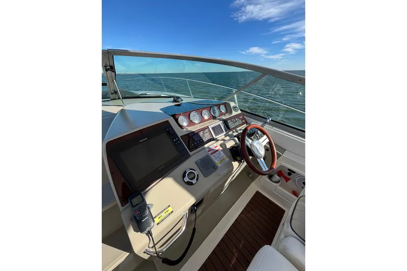 Slide: The Image of Cockpit view of 2010 Sea Ray 370 Sundancer, featuring steering wheel and navigation instruments. - 21
