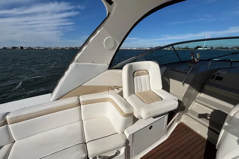 Slide: The Image of 2010 Sea Ray 370 Sundancer boat interior with white seating and ocean view. - 23
