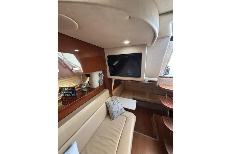 Slide: The Image of Interior of 2010 Sea Ray 370 Sundancer with beige seating and mounted TV. - 33