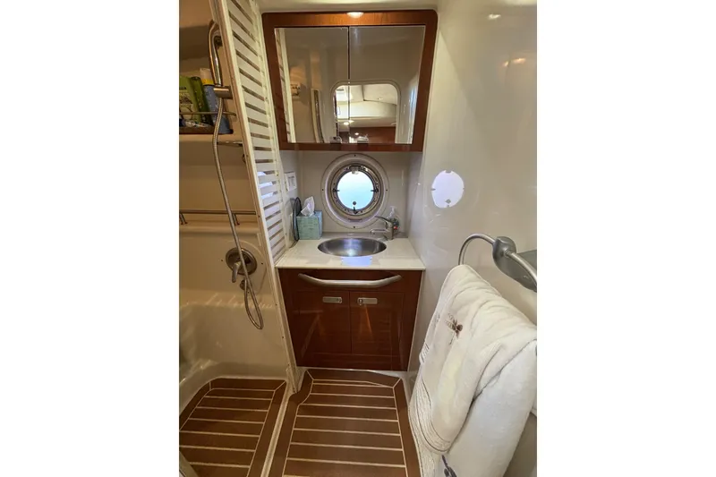 Slide: The Image of Luxurious bathroom in 2010 Sea Ray 370 Sundancer yacht with porthole and wooden accents. - 34