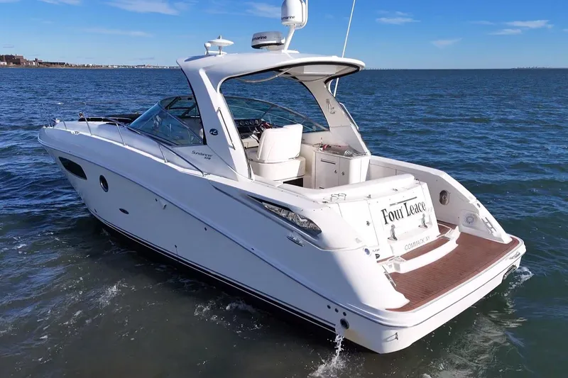 Slide: The Image of 2010 Sea Ray 370 Sundancer yacht cruising on open water under clear blue skies. - 4