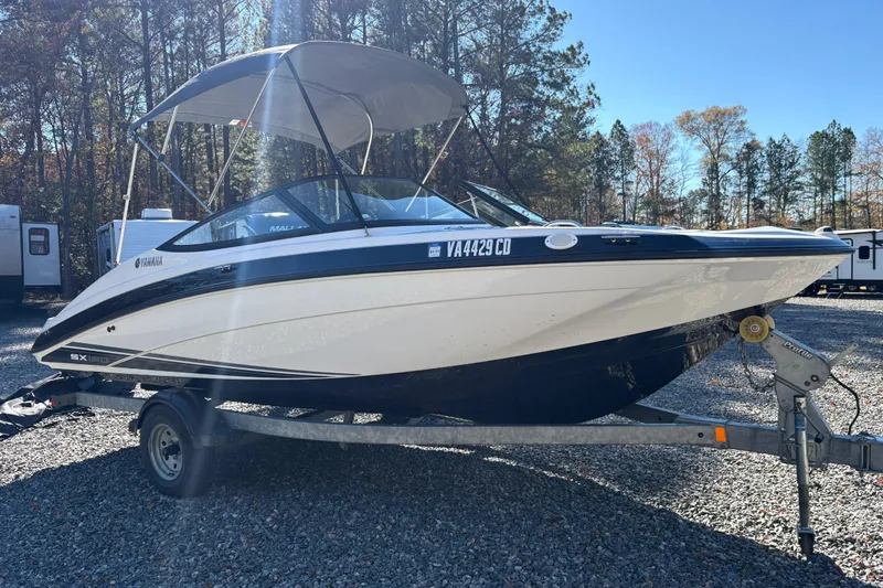 Slide: The Image of 2018 Yamaha SX190 boat on trailer, parked outdoors with trees in background. - 3