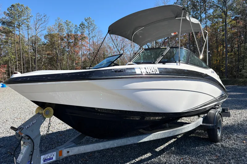 Slide: The Image of 2018 Yamaha SX190 boat on trailer, parked outdoors with trees in background. - 4