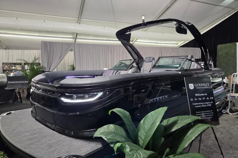 Slide: The Image of 2026 Godfrey Sanpan 2700 SBW Twin luxury pontoon boat on display indoors. - 5