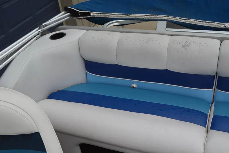 Slide: The Image of 1992 Manitou SPORT boat interior with blue and white seating, featuring cup holder. - 13