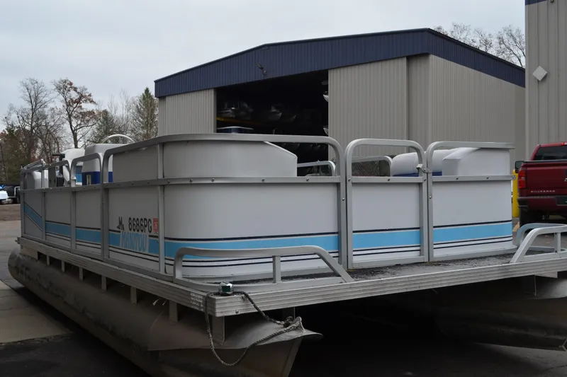 Slide: The Image of 1992 Manitou SPORT pontoon boat parked near a warehouse. - 4