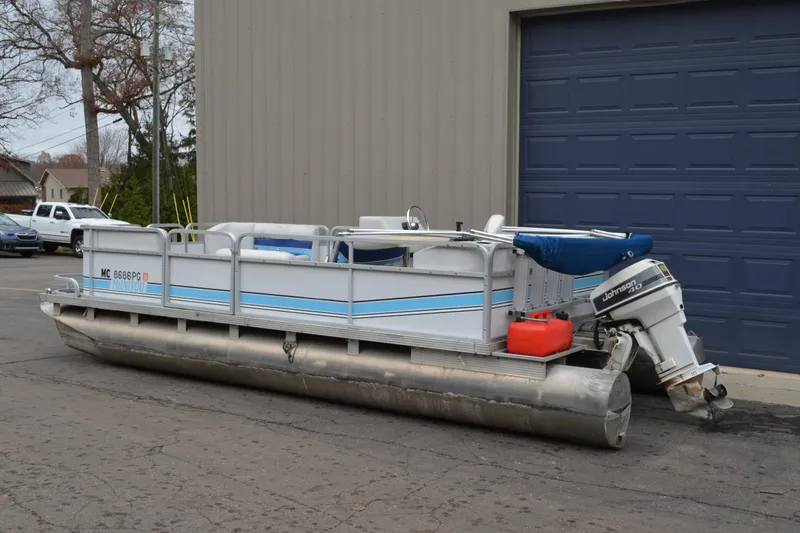 Slide: The Image of 1992 Manitou SPORT pontoon boat with Johnson 40 outboard motor, parked outdoors. - 5