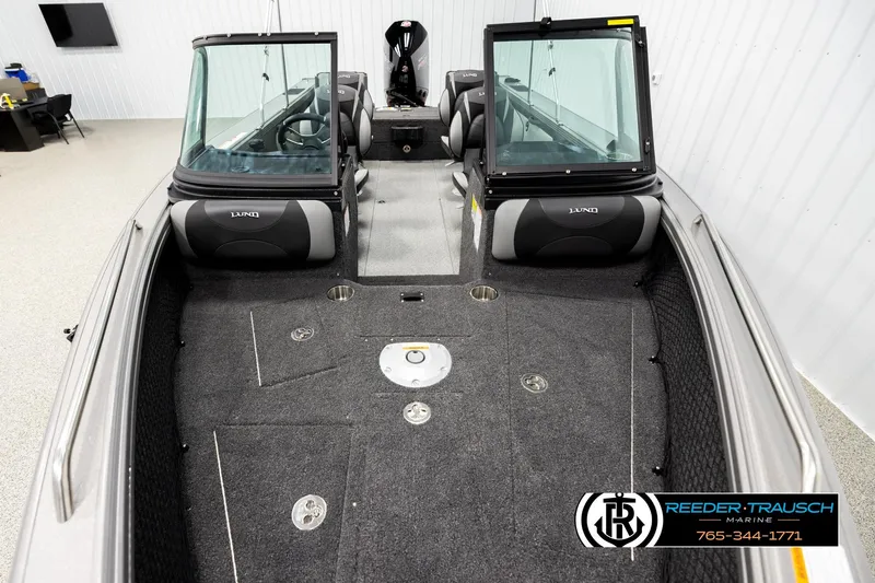 Slide: The Image of 2026 Lund 1975 Tyee boat interior with seating and windshield in showroom. - 16