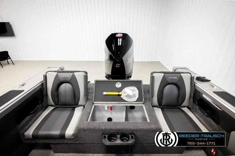 Slide: The Image of 2026 Lund 1975 Tyee boat interior with seating and motor, displayed in showroom. - 19