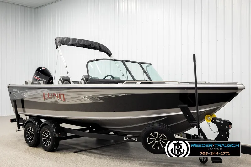 Slide: The Image of 2026 Lund 1975 Tyee boat on trailer in showroom, featuring sleek design and modern features. - 2