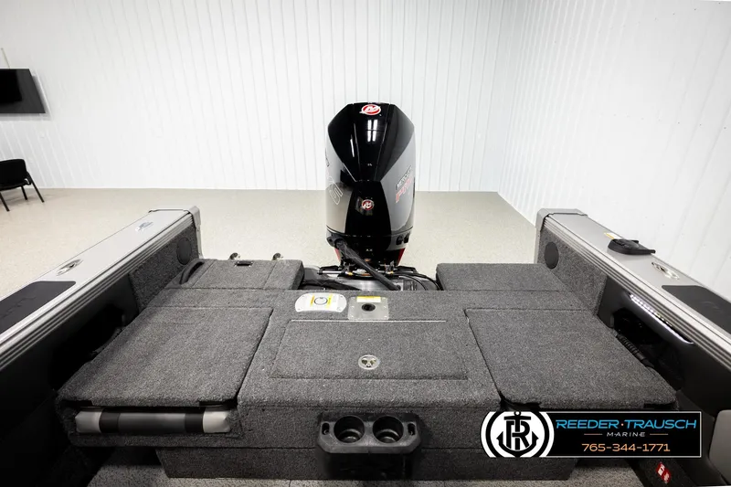 Slide: The Image of 2026 Lund 1975 Tyee boat interior with motor, showcased in a showroom. - 20