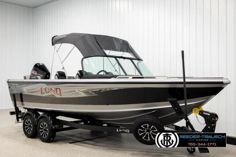 Slide: The Image of 2026 Lund 1975 Tyee boat with canopy on trailer in showroom. - 3