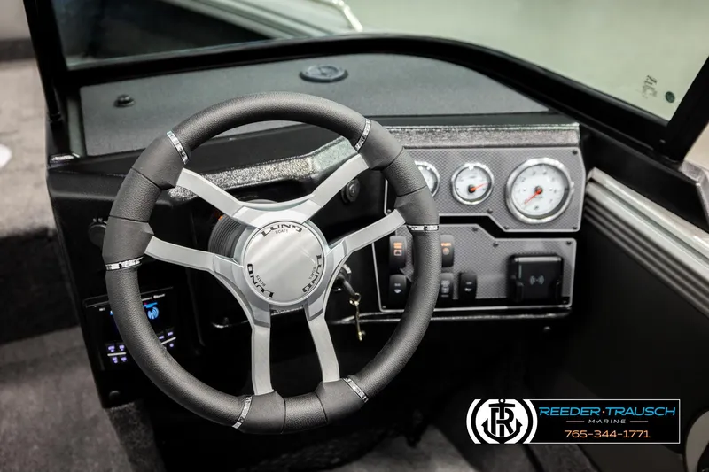 Slide: The Image of Steering wheel and dashboard of 2026 Lund 1975 Tyee boat, featuring modern controls. - 36
