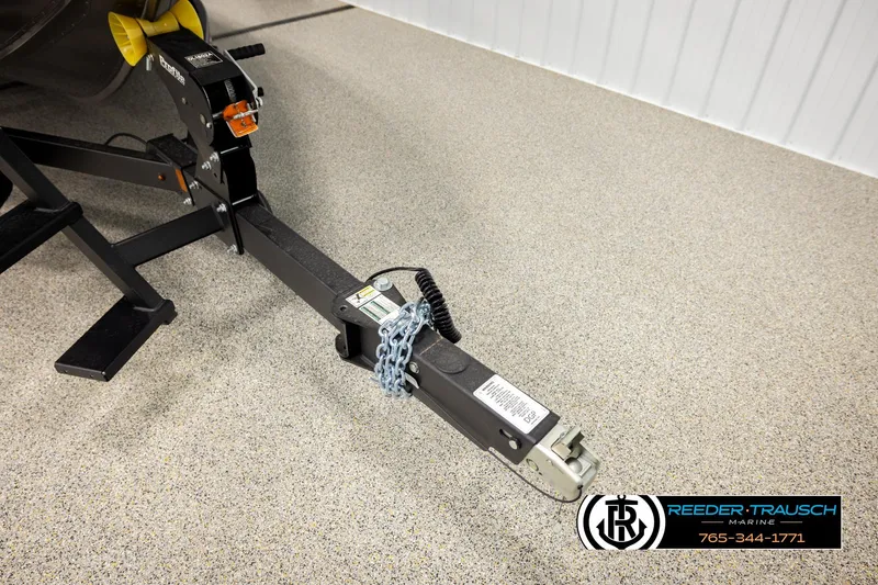 Slide: The Image of Trailer hitch of 2026 Lund 1975 Tyee boat, secured with chain, on speckled floor. - 50