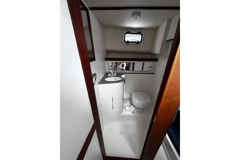 Slide: The Image of 2021 NorthCoast 315 Cabin boat bathroom with sink, toilet, and mirror. - 14