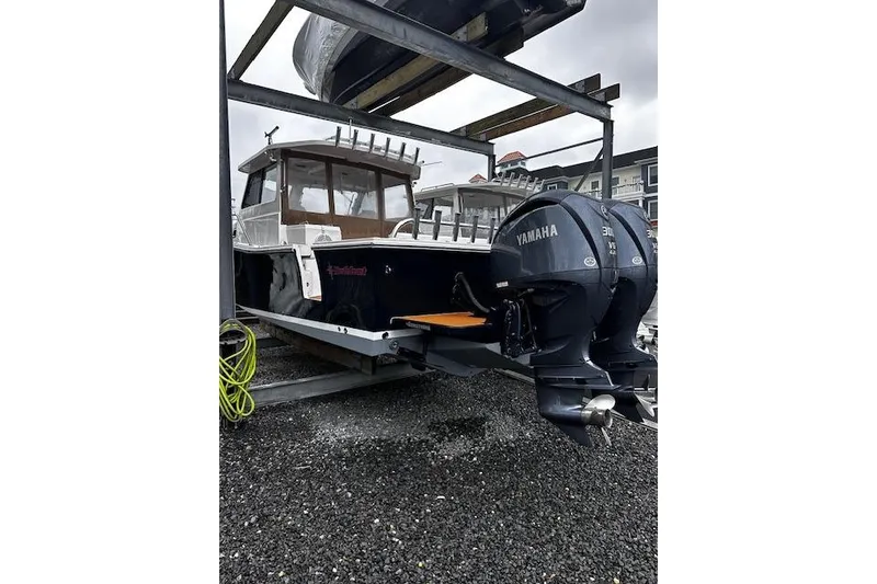 Slide: The Image of 2021 NorthCoast 315 Cabin boat with Yamaha engines on a gravel surface. - 4