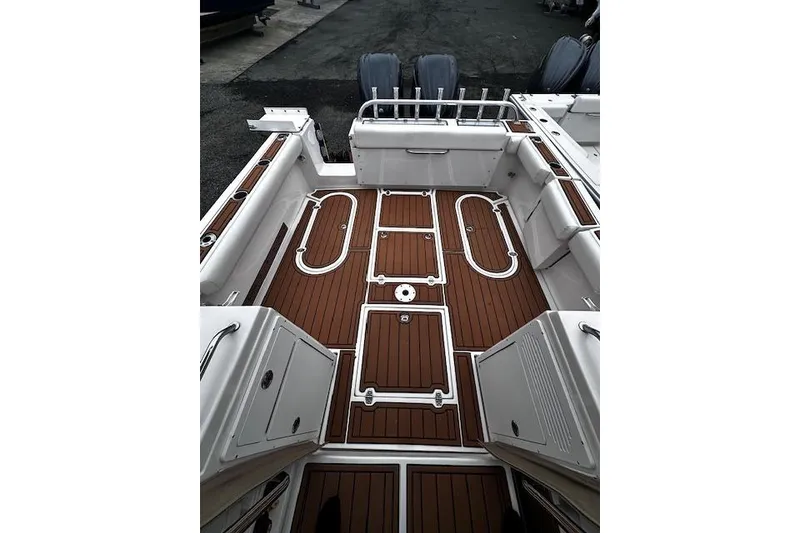 Slide: The Image of 2021 NorthCoast 315 Cabin boat deck with wood finish and storage compartments. - 7