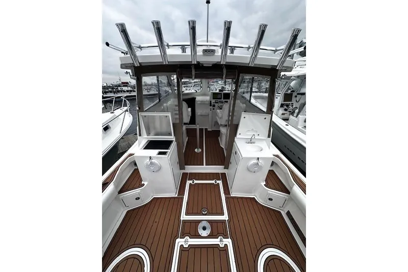 Slide: The Image of 2021 NorthCoast 315 Cabin boat interior with wood flooring and fishing rod holders. - 8