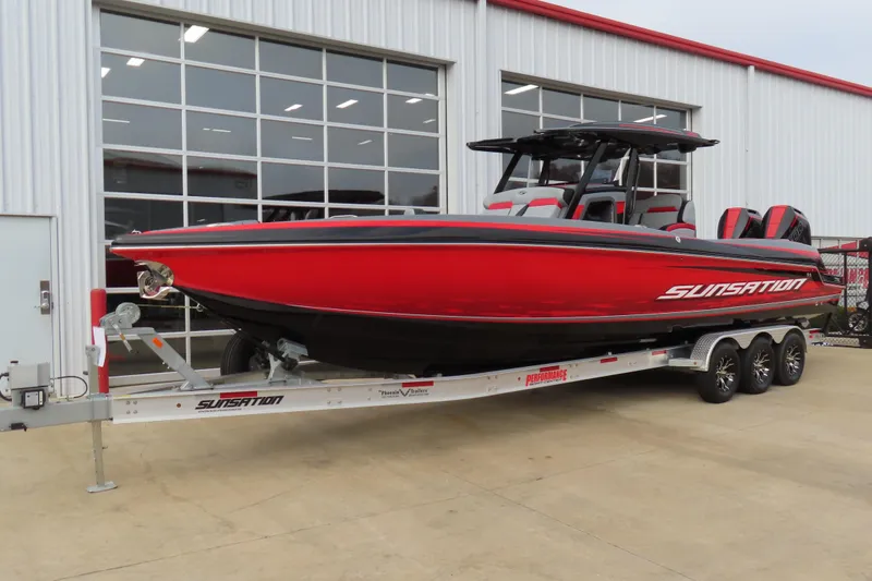 Slide: The Image of 2025 Sunsation 32 CCX boat in vibrant red on a trailer outside a showroom. - 3