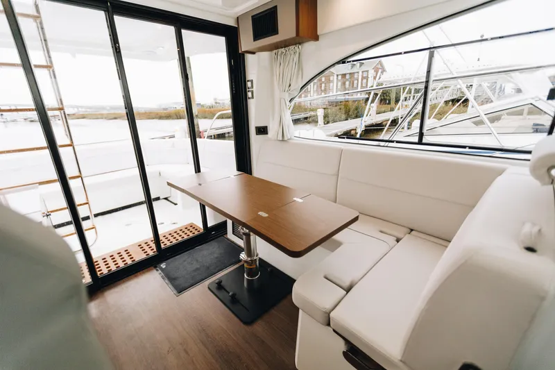 Slide: The Image of Luxurious interior of 2026 Beneteau Antares 11 Fly with elegant seating and wooden table. - 14