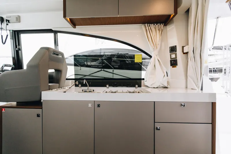 Slide: The Image of Interior of 2026 Beneteau Antares 11 Fly yacht, featuring modern kitchen and helm station. - 15