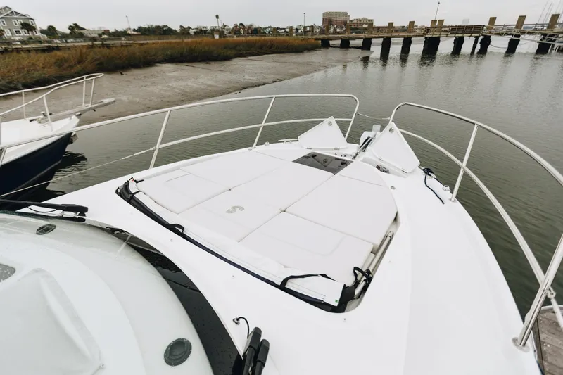 Slide: The Image of 2026 Beneteau Antares 11 Fly yacht bow view with sunpad, docked near bridge. - 16