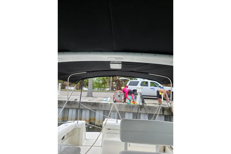 Slide: The Image of 2002 Tiara Yachts 3500 Open view from interior, dockside with people and vehicle. - 13