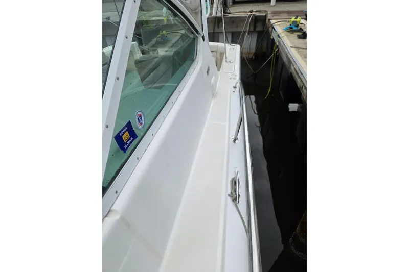 Slide: The Image of 2002 Tiara Yachts 3500 Open docked, showcasing sleek white exterior and window decals. - 17