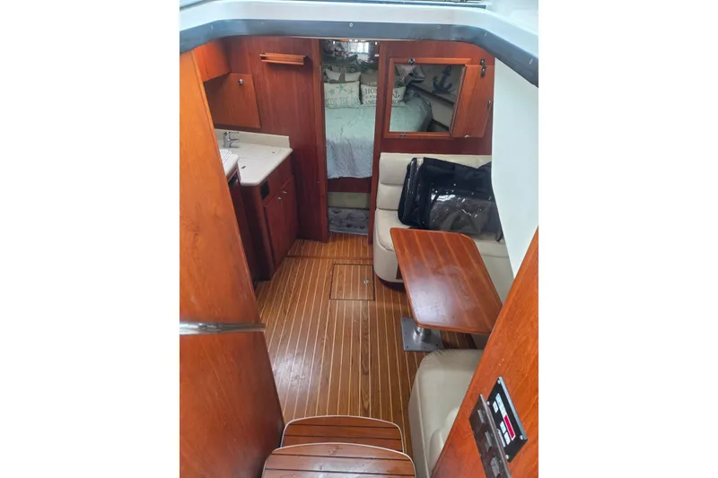 Slide: The Image of Interior of 2002 Tiara Yachts 3500 Open with wood finish and seating area. - 19
