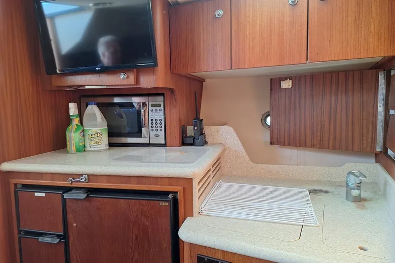 Slide: The Image of 2002 Tiara 3500 Open yacht interior with kitchenette, microwave, and TV. - 20