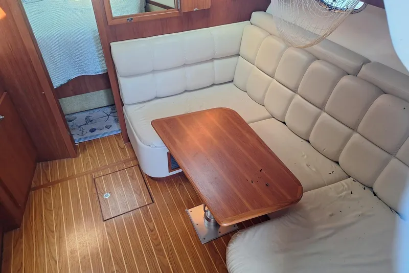 Slide: The Image of Interior of 2002 Tiara 3500 Open yacht with cushioned seating and wooden table. - 7