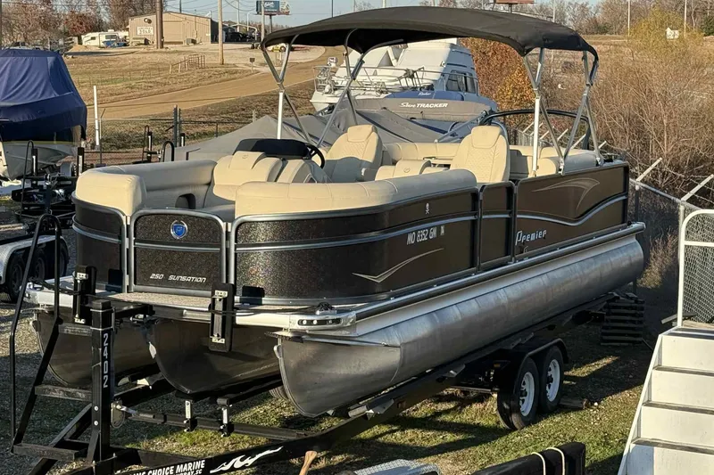 Slide: The Image of 2021 Premier 250 RE Sunsation LTD pontoon boat on trailer, outdoor setting. - 14